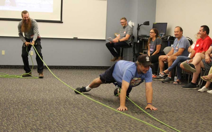 Adults participate in an exercise using ropes during a family seminar with outward bound.